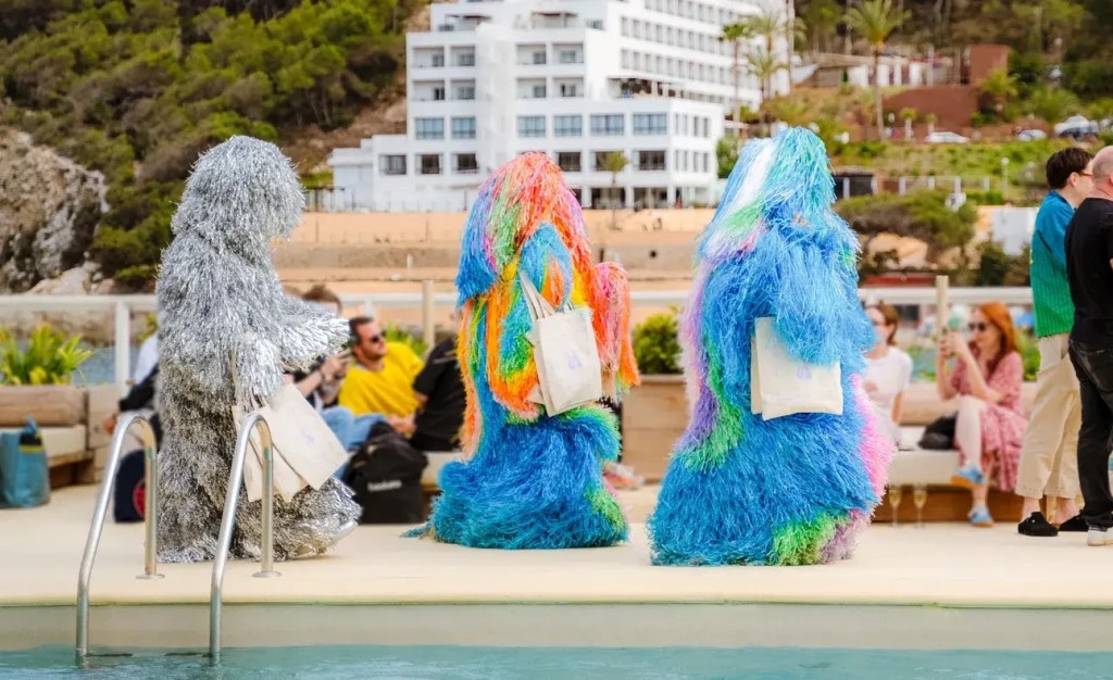 3 people walking along the street with big furry costumes