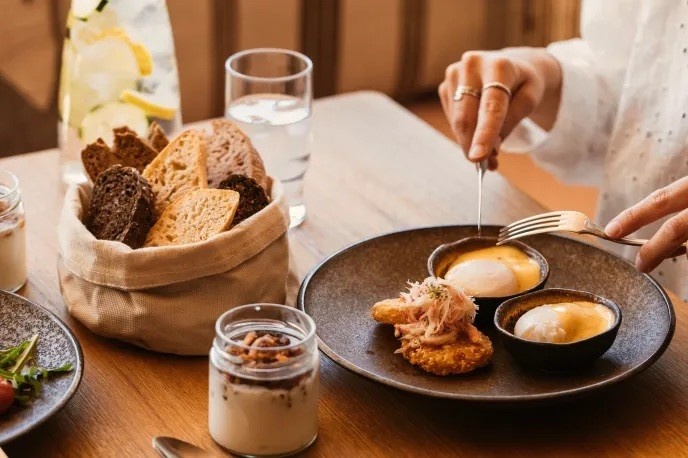 table with multiple breakfast options including muesli, bread and eggs