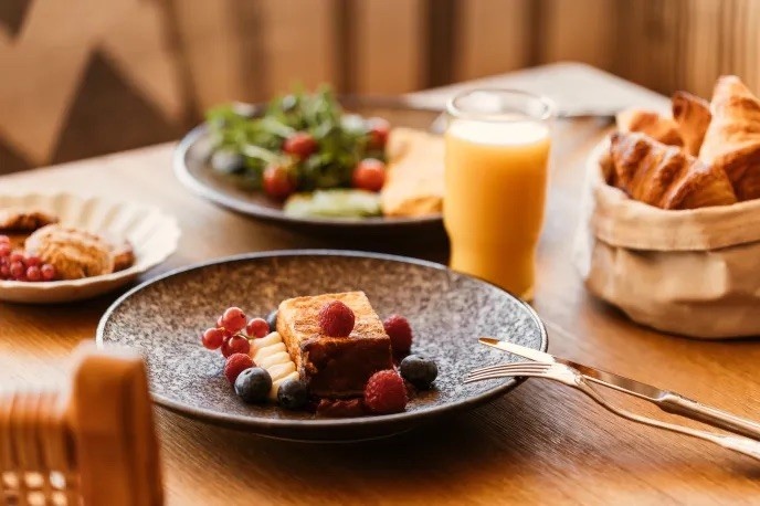 table with multiple breakfast options including an orange juice and french toast